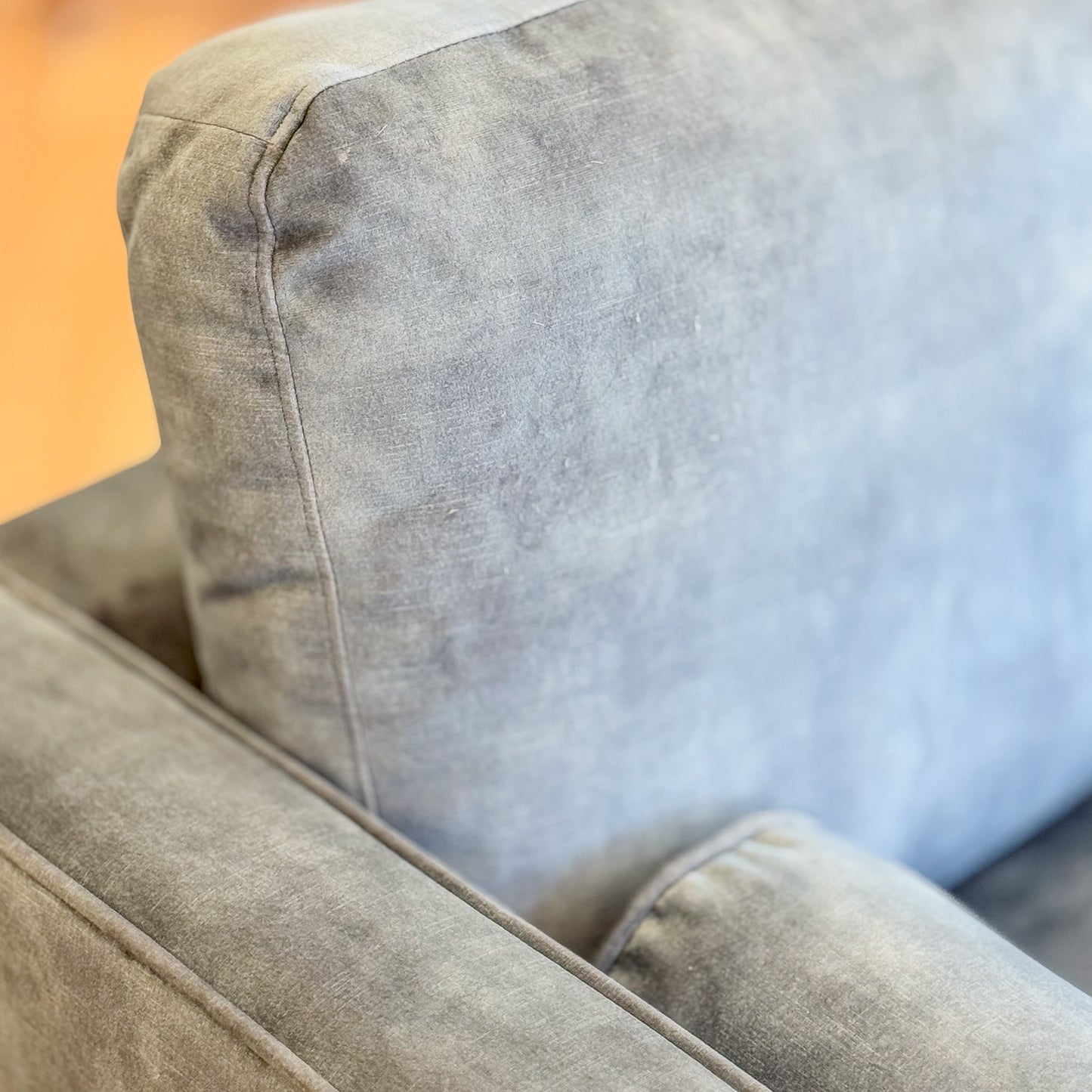 Blue suede armchair with loose bolster cushions