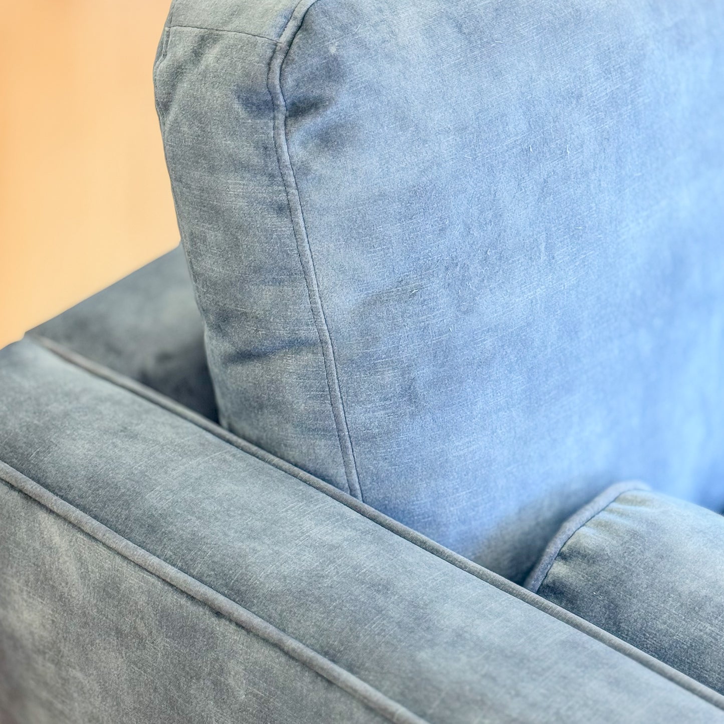 Blue suede armchair with loose bolster cushions