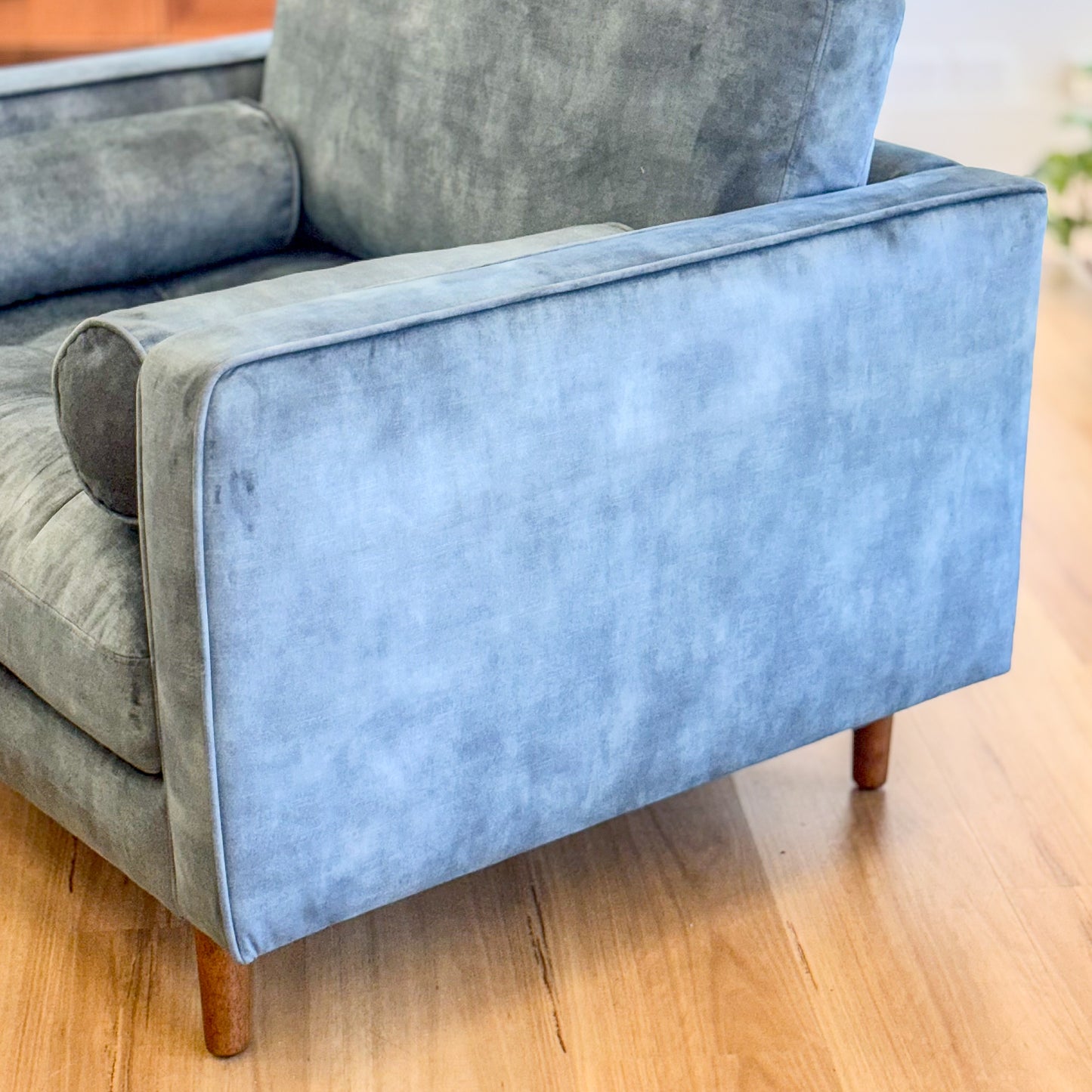 Blue suede armchair with loose bolster cushions