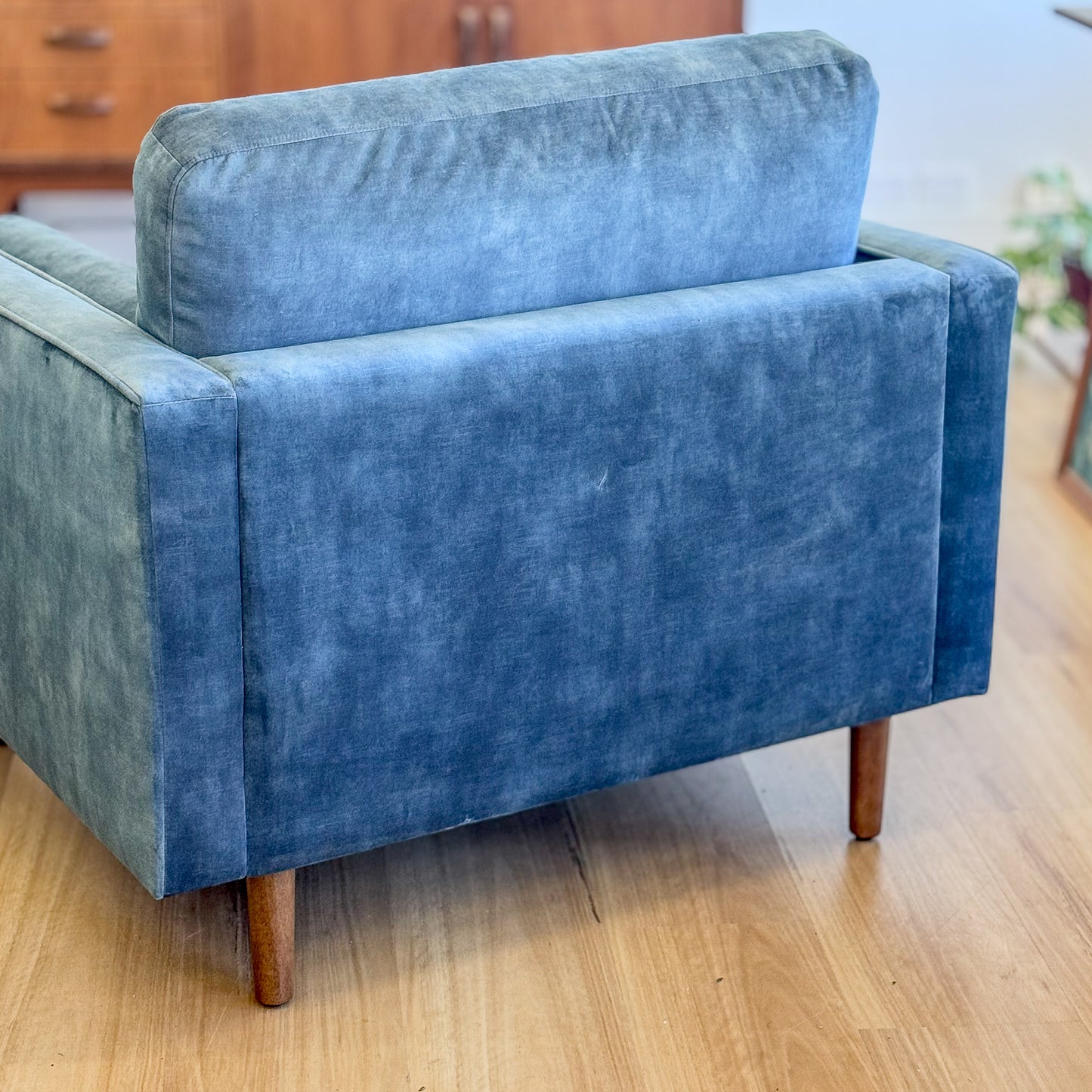 Blue suede armchair with loose bolster cushions