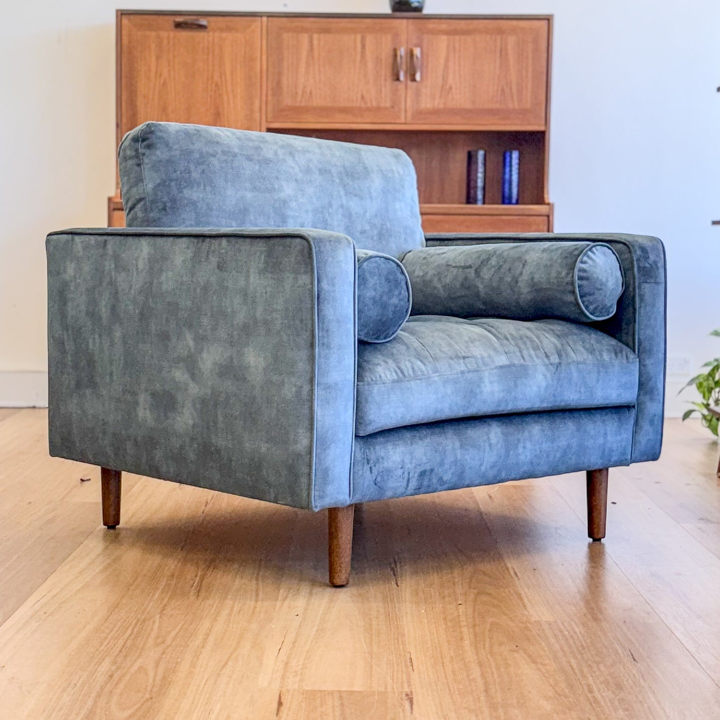 Blue suede armchair with loose bolster cushions