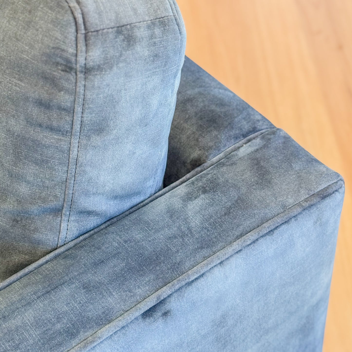 Blue suede armchair with loose bolster cushions