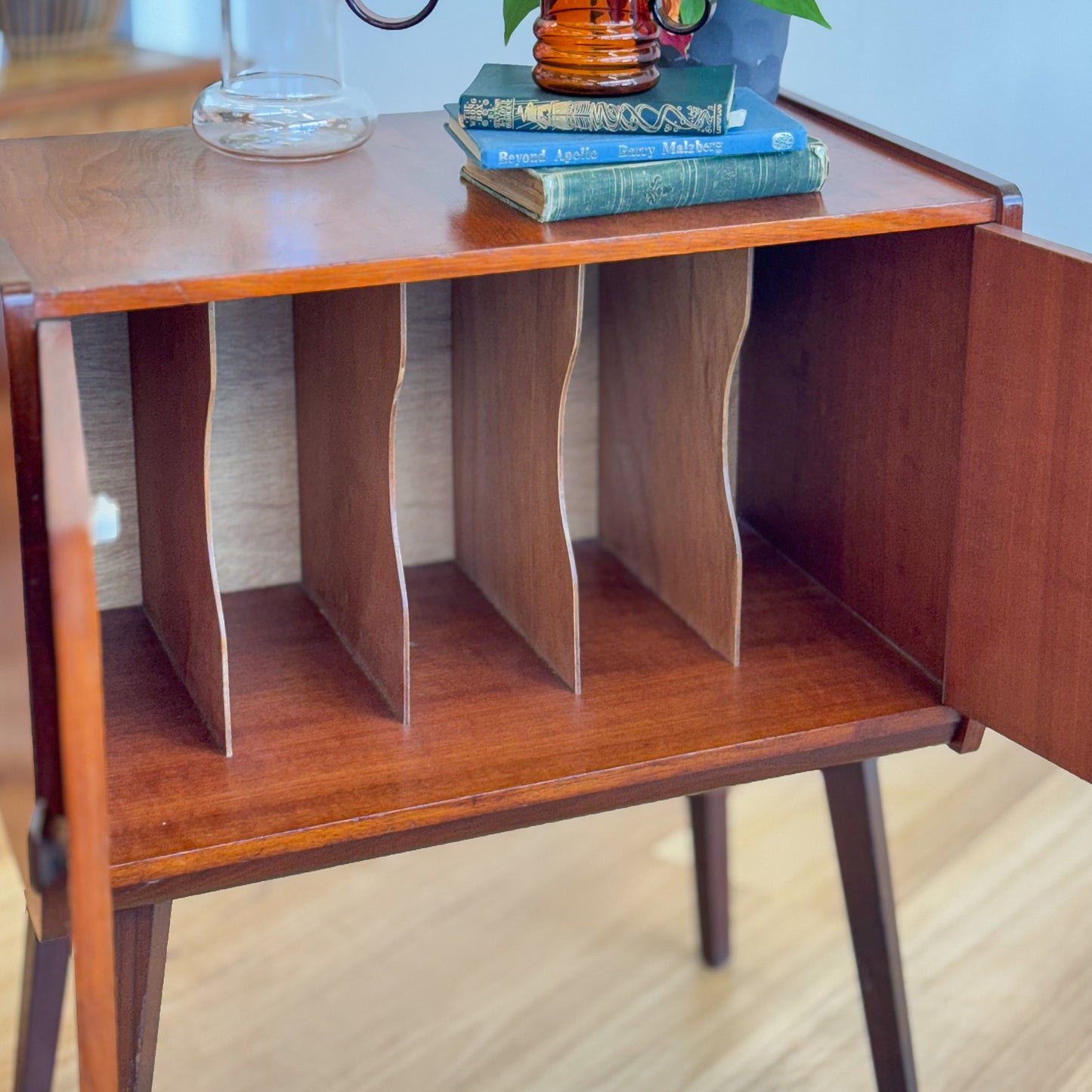 A vintage teak two door record cabinet