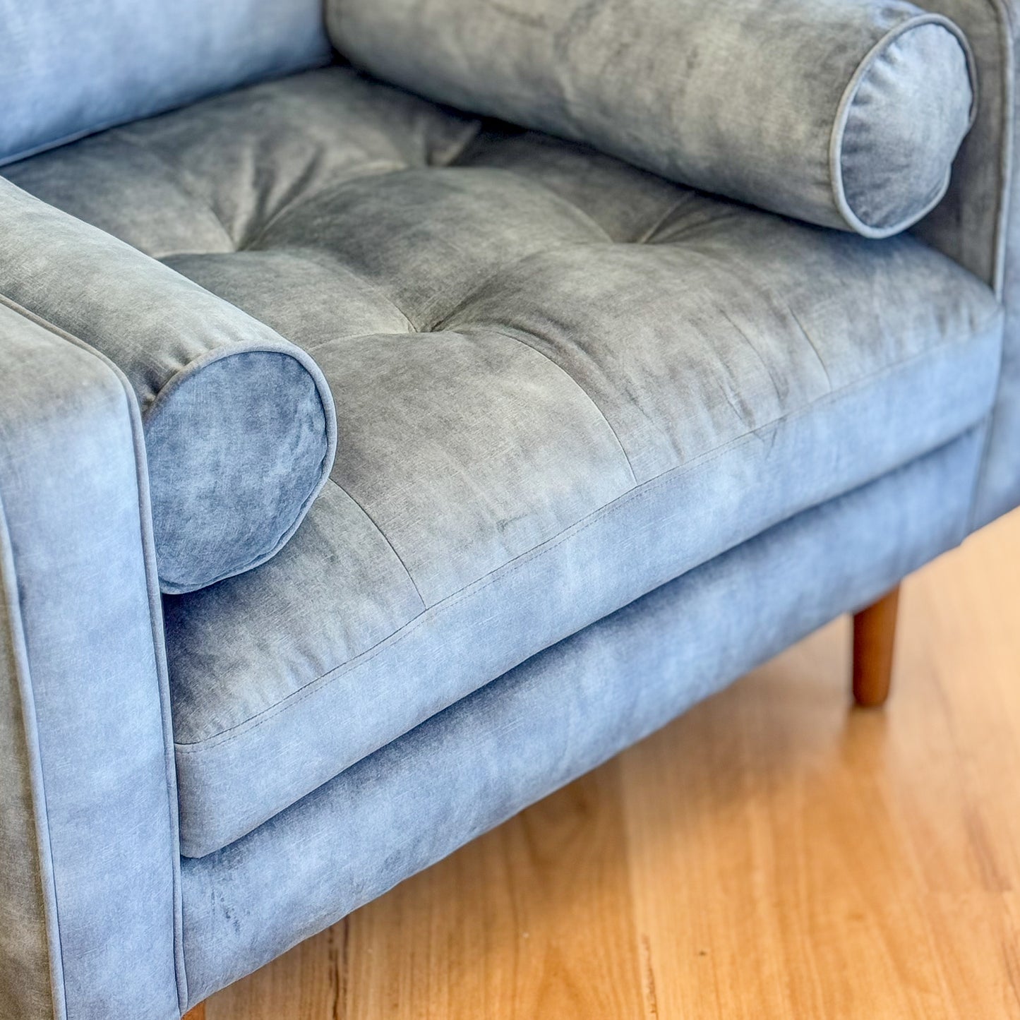 Blue suede armchair with loose bolster cushions