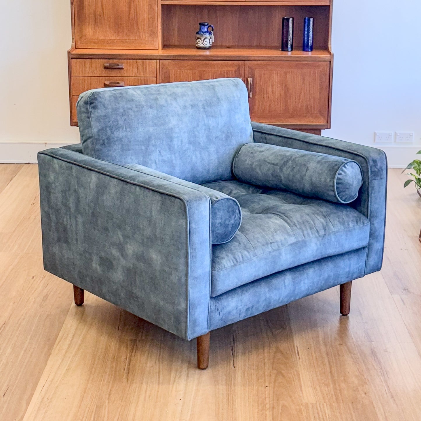 Blue suede armchair with loose bolster cushions